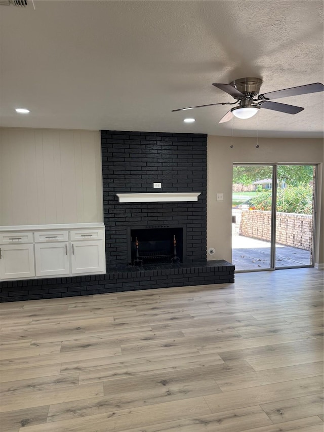 711 S Farmington Rd, Howe, TX 75459 - unfurnished living room with ceiling fan, light wood-style floors, a fireplace, a textured ceiling, and recessed lighting