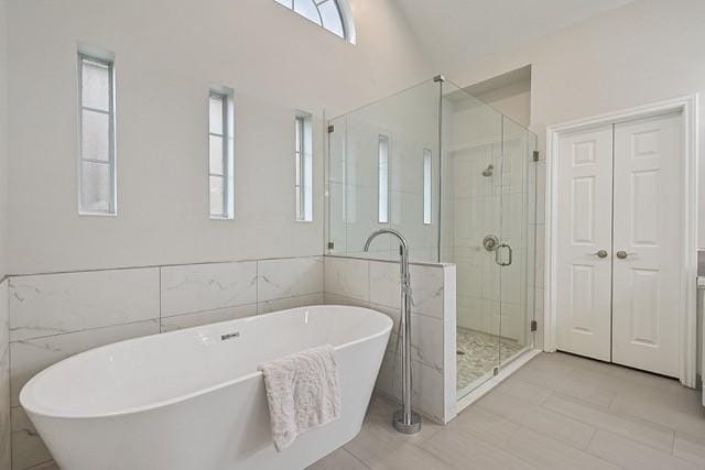 711 Saratoga Dr, Southlake, TX 76092 - bathroom with plenty of natural light, a shower stall, a freestanding tub, and tile walls