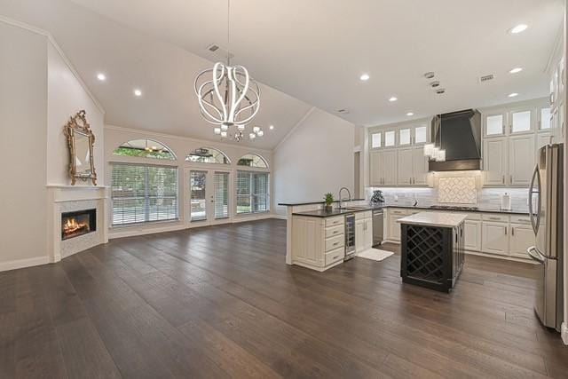 711 Saratoga Dr, Southlake, TX 76092 - kitchen featuring wall chimney exhaust hood, wine cooler, open floor plan, stainless steel appliances, and a chandelier