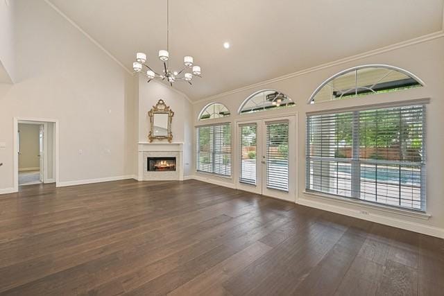 711 Saratoga Dr, Southlake, TX 76092 - unfurnished living room featuring a chandelier, healthy amount of natural light, high vaulted ceiling, wood finished floors, and baseboards