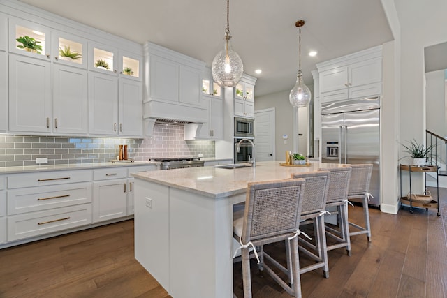 410 Travelers Ter, Argyle, TX 76226 - kitchen featuring built in appliances, a sink, tasteful backsplash, a kitchen bar, and white cabinetry