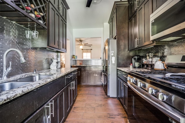 101 E Mulberry St, Decatur, TX 76234 - kitchen featuring appliances with stainless steel finishes, decorative backsplash, light stone countertops, a sink, and dark wood-style flooring