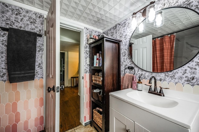 101 E Mulberry St, Decatur, TX 76234 - bathroom featuring wallpapered walls, vanity, and wood finished floors