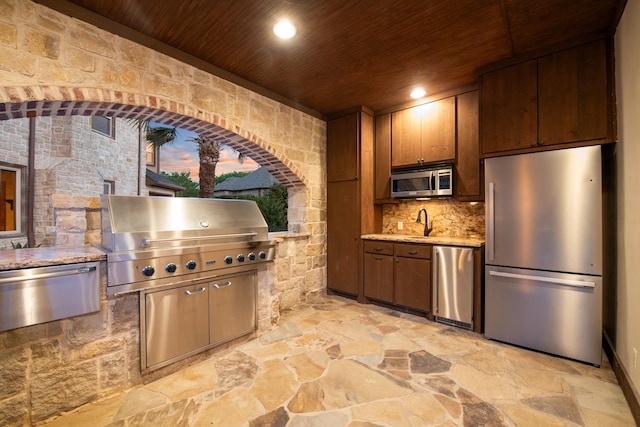 1612 S Lakeshore Dr, Rockwall, TX 75087 - kitchen featuring appliances with stainless steel finishes, wooden ceiling, stone floors, decorative backsplash, and recessed lighting