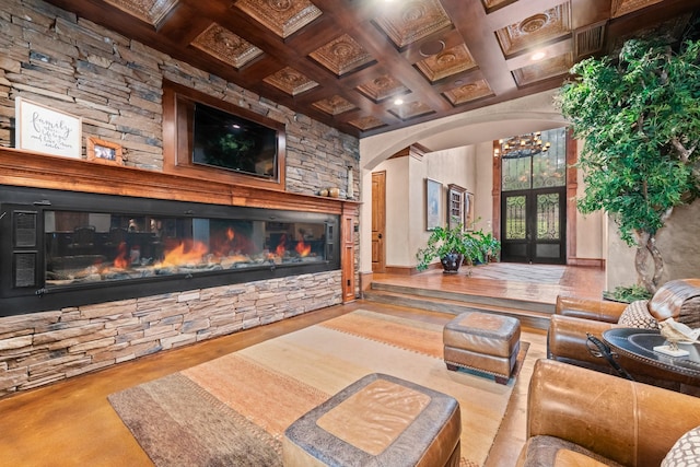 1612 S Lakeshore Dr, Rockwall, TX 75087 - living area featuring arched walkways, french doors, a glass covered fireplace, beamed ceiling, and coffered ceiling