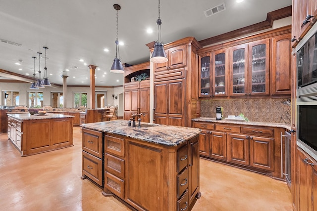 1612 S Lakeshore Dr, Rockwall, TX 75087 - kitchen with a kitchen island with sink, a sink, decorative backsplash, brown cabinetry, and recessed lighting