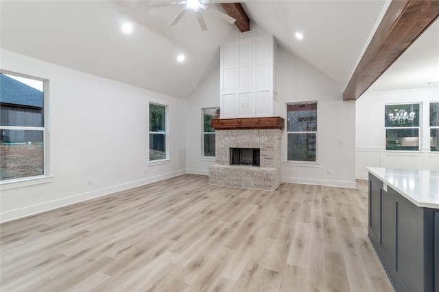 216 Pauline St, Arp, TX 75750 - unfurnished living room with beamed ceiling, ceiling fan, a brick fireplace, high vaulted ceiling, and light wood-type flooring