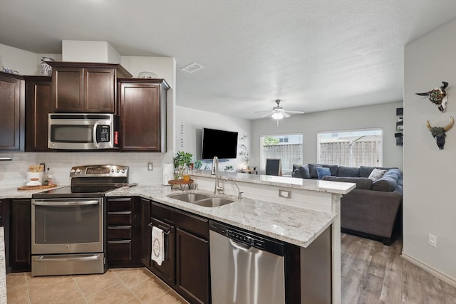 7113 Creighton Ct, Fort Worth, TX 76120 - kitchen featuring stainless steel appliances, a sink, a peninsula, open floor plan, and ceiling fan