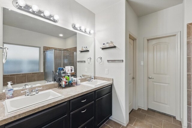 7113 Creighton Ct, Fort Worth, TX 76120 - bathroom with a shower stall, double vanity, tile patterned floors, and a tub to relax in