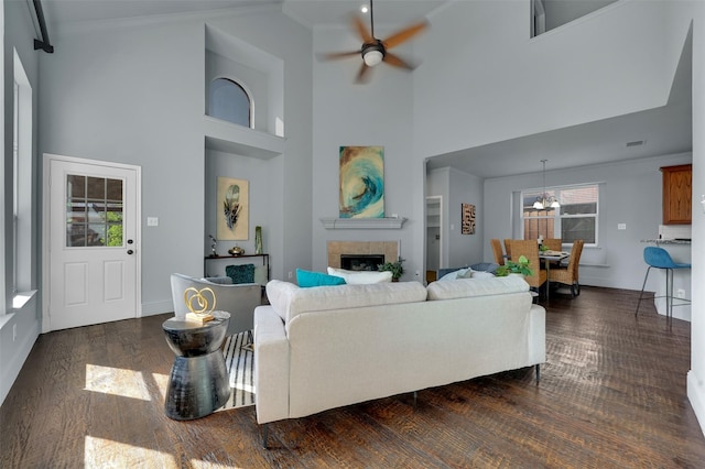 1102 Mccormick St, Garland, TX 75040 - living area featuring a ceiling fan, a towering ceiling, a fireplace, dark wood finished floors, and baseboards