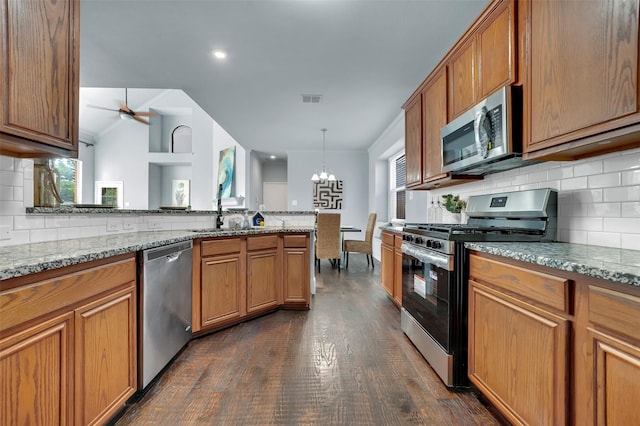 1102 Mccormick St, Garland, TX 75040 - kitchen with appliances with stainless steel finishes, backsplash, dark wood finished floors, ceiling fan, and brown cabinetry
