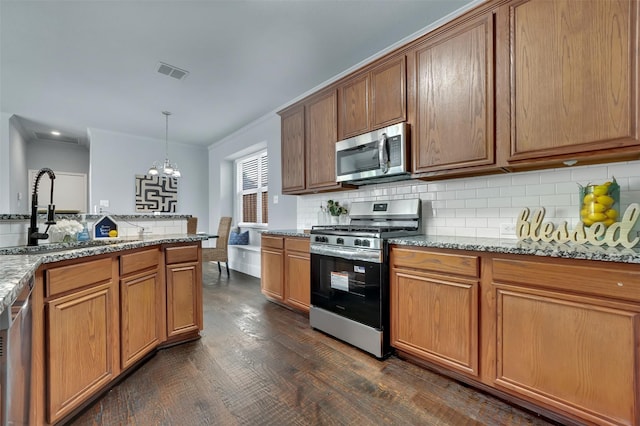 1102 Mccormick St, Garland, TX 75040 - kitchen featuring stainless steel appliances, a chandelier, a sink, backsplash, and dark wood-type flooring