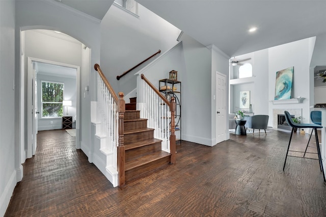 1102 Mccormick St, Garland, TX 75040 - stairway with arched walkways, a ceiling fan, baseboards, wood finished floors, and a tiled fireplace