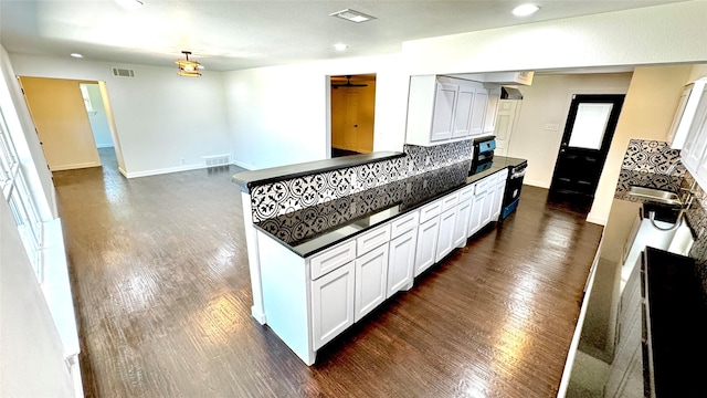 3315 Cedarcroft Ln, Dallas, TX 75233 - kitchen featuring dark countertops, dark wood-style flooring, recessed lighting, white cabinetry, and baseboards
