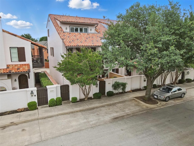 261 Casa Blanca Ave, Fort Worth, TX 76107 - view of front facade with a gate, stucco siding, a tiled roof, and a fenced front yard