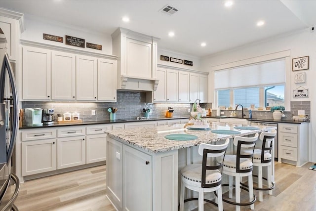 10116 T Bury Ln, Waco, TX 76708 - kitchen featuring ornamental molding, stainless steel refrigerator, decorative backsplash, a center island, and white cabinetry
