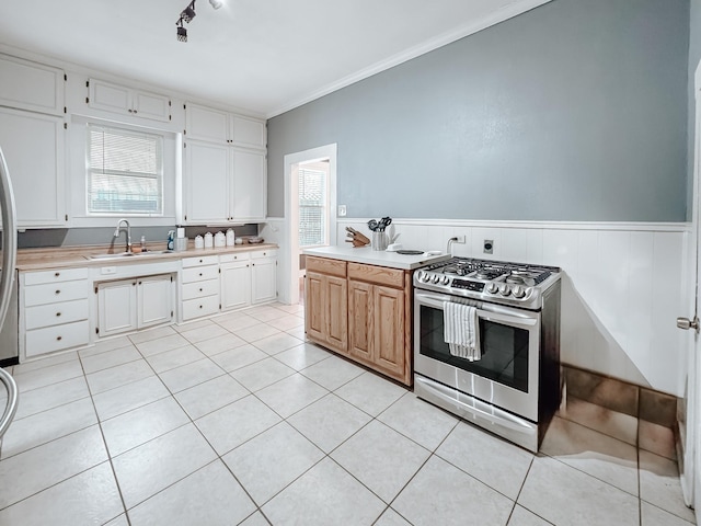 1530 W 5th Ave, Corsicana, TX 75110 - kitchen with stainless steel gas range, a sink, light countertops, light tile patterned flooring, and ornamental molding