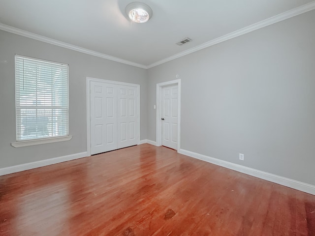 1530 W 5th Ave, Corsicana, TX 75110 - unfurnished bedroom with light wood-style flooring, crown molding, and baseboards