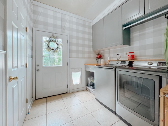 1530 W 5th Ave, Corsicana, TX 75110 - laundry area featuring cabinet space, washing machine and dryer, ornamental molding, light tile patterned floors, and wallpapered walls