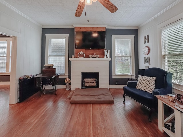 1530 W 5th Ave, Corsicana, TX 75110 - living area with wood finished floors, ceiling fan, healthy amount of natural light, ornamental molding, and a brick fireplace