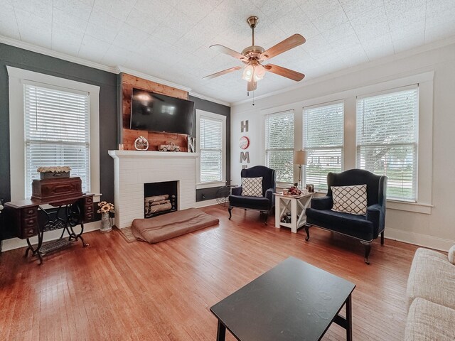 1530 W 5th Ave, Corsicana, TX 75110 - living room featuring wood finished floors, ornamental molding, ceiling fan, and a fireplace