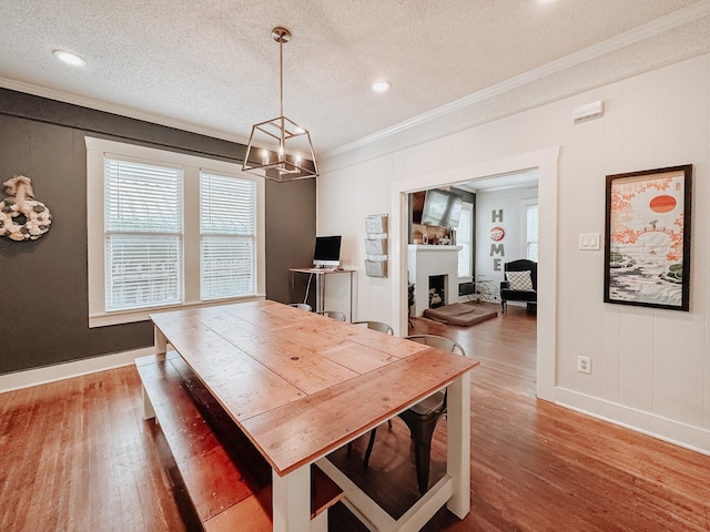 1530 W 5th Ave, Corsicana, TX 75110 - dining space featuring ornamental molding, healthy amount of natural light, wood finished floors, a chandelier, and a textured ceiling