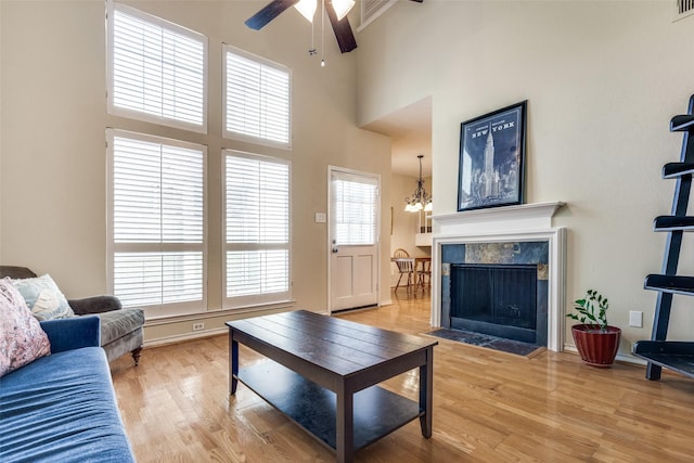 6220 Bentwood Trl Unit 907, Dallas, TX 75252 - living area featuring wood finished floors, a ceiling fan, a towering ceiling, a fireplace, and baseboards