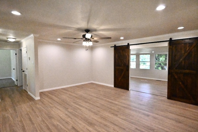 220 Seabreeze Dr, Gun Barrel City, TX 75156 - spare room featuring a barn door, baseboards, wood finished floors, recessed lighting, and a ceiling fan