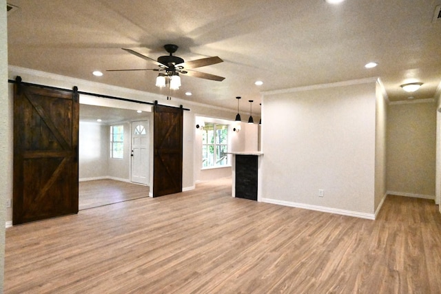 220 Seabreeze Dr, Gun Barrel City, TX 75156 - spare room with a barn door, crown molding, a ceiling fan, light wood finished floors, and baseboards