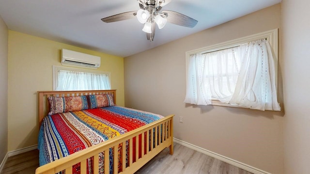 150 David St, Jefferson, TX 75657 - bedroom with an AC wall unit, wood finished floors, baseboards, and a ceiling fan