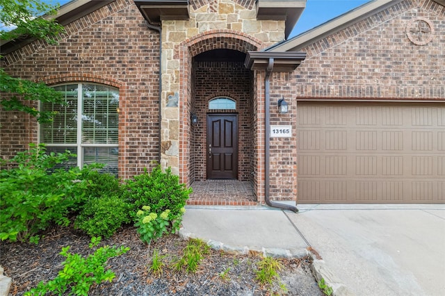13165 Red Robin Dr, Fort Worth, TX 76244 - property entrance featuring brick siding, an attached garage, and concrete driveway