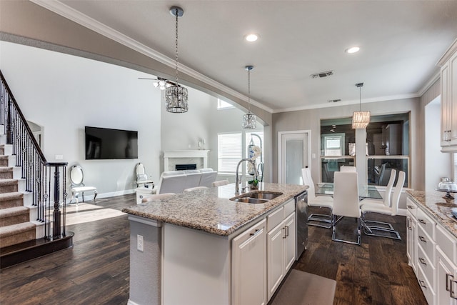 6829 Fire Dance Dr, Benbrook, TX 76126 - kitchen featuring a sink, a fireplace, white cabinets, dark wood finished floors, and ornamental molding