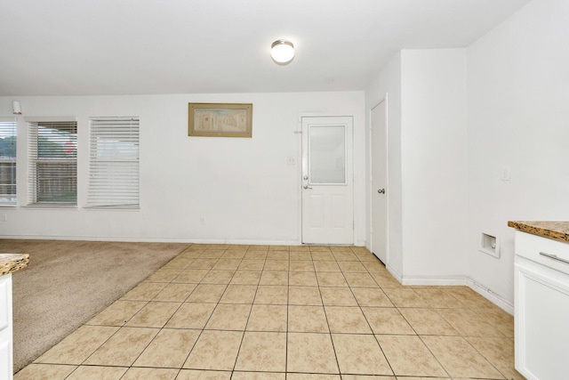 6021 Lucas Ct, Fort Worth, TX 76119 - empty room featuring light tile patterned floors, baseboards, and light carpet