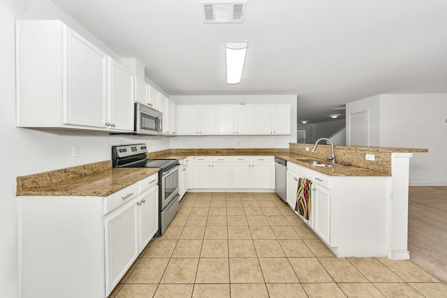 6021 Lucas Ct, Fort Worth, TX 76119 - kitchen featuring stainless steel appliances, a sink, a peninsula, stone countertops, and light tile patterned flooring