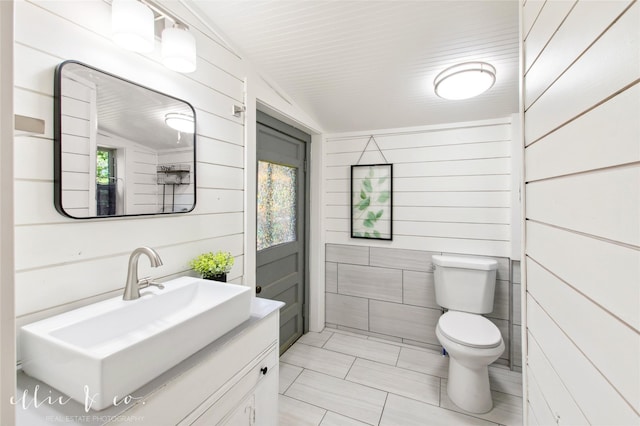 400 Riverside Blvd, Abilene, TX 79605 - bathroom featuring toilet, vanity, wooden walls, and tile patterned flooring