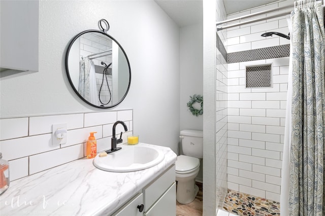 400 Riverside Blvd, Abilene, TX 79605 - full bathroom with toilet, vanity, a tile shower, backsplash, and wood finished floors