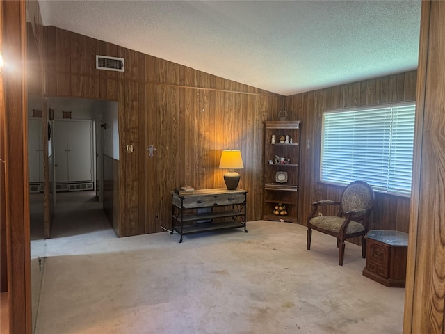 1614 Savage Dr, Mesquite, TX 75149 - sitting room featuring vaulted ceiling, wooden walls, a textured ceiling, and carpet floors