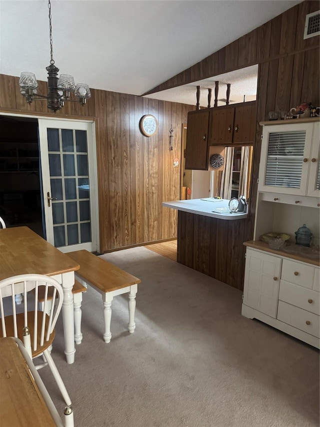 1614 Savage Dr, Mesquite, TX 75149 - dining space featuring wooden walls, light colored carpet, lofted ceiling, and a chandelier