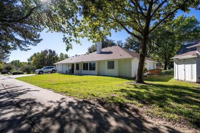 1505 Williamsburg Ct, Ennis, TX 75119 - view of front facade featuring a front lawn, a chimney, an attached garage, and brick siding