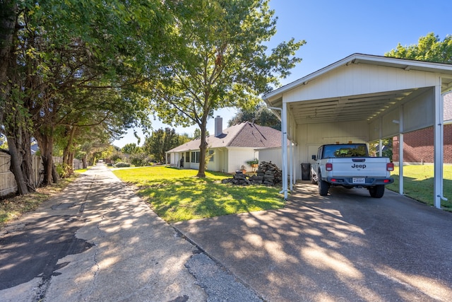 1505 Williamsburg Ct, Ennis, TX 75119 - view of side of home featuring asphalt driveway, a yard, and a detached carport