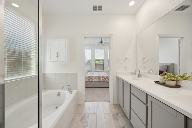 2004 Creekridge Dr, Lewisville, TX 75010 - bathroom featuring connected bathroom, a garden tub, double vanity, a ceiling fan, and recessed lighting