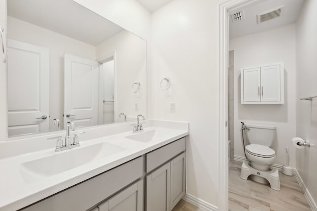 2004 Creekridge Dr, Lewisville, TX 75010 - bathroom with wood finished floors, toilet, baseboards, and double vanity