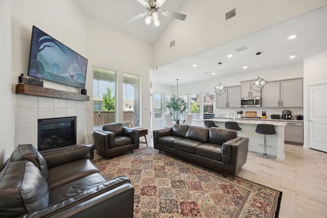 2004 Creekridge Dr, Lewisville, TX 75010 - living area featuring plenty of natural light, a ceiling fan, recessed lighting, a tiled fireplace, and a towering ceiling