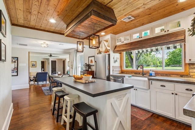 3227 Macarthur Dr, Waco, TX 76708 - kitchen with wood ceiling, a sink, dark countertops, white cabinetry, and stainless steel appliances