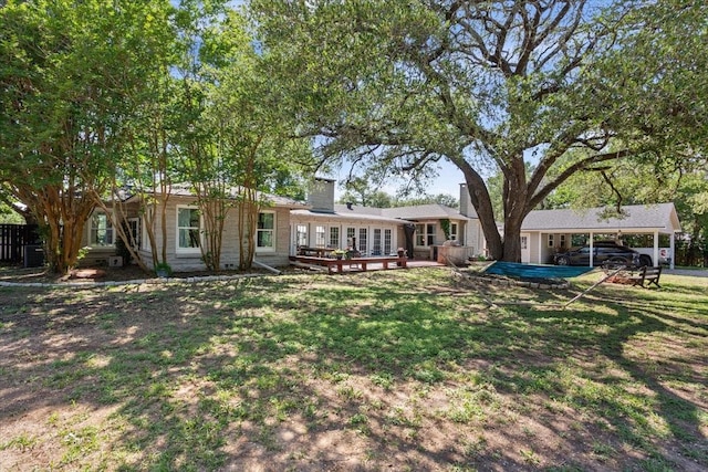 3227 Macarthur Dr, Waco, TX 76708 - rear view of house with a wooden deck, a lawn, a chimney, and a carport