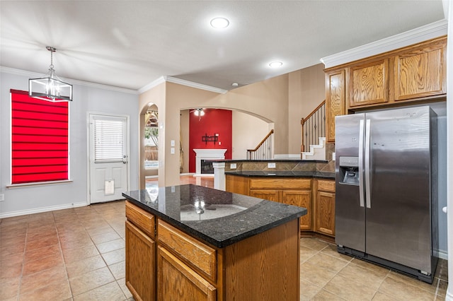 3737 Monica Ln, Fort Worth, TX 76244 - kitchen featuring stainless steel fridge, arched walkways, brown cabinetry, light tile patterned floors, and ornamental molding