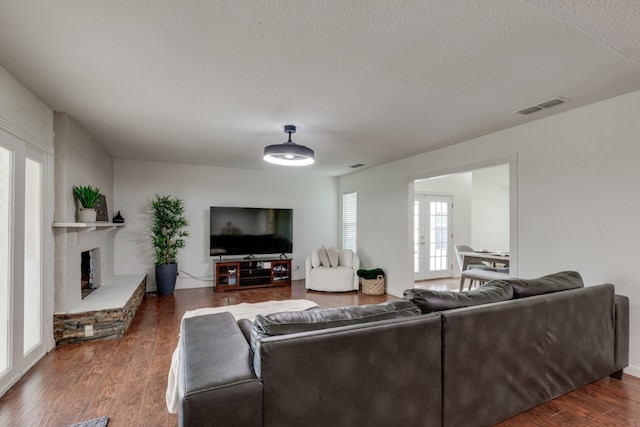 3510 Knoll Point Dr, Garland, TX 75043 - living area featuring wood finished floors, a fireplace with raised hearth, and a textured ceiling