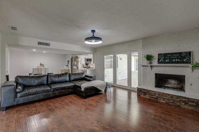 3510 Knoll Point Dr, Garland, TX 75043 - living area with a fireplace, wood finished floors, and a textured ceiling