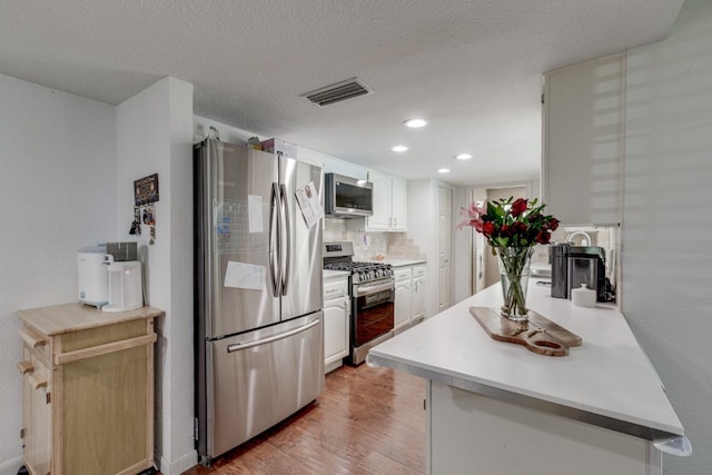 3510 Knoll Point Dr, Garland, TX 75043 - kitchen featuring appliances with stainless steel finishes, light wood finished floors, recessed lighting, white cabinets, and backsplash