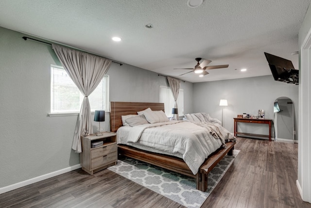 3510 Knoll Point Dr, Garland, TX 75043 - bedroom featuring arched walkways, wood finished floors, a textured ceiling, baseboards, and recessed lighting